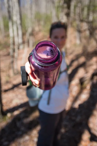 Woman Offers Purple Water Bottle