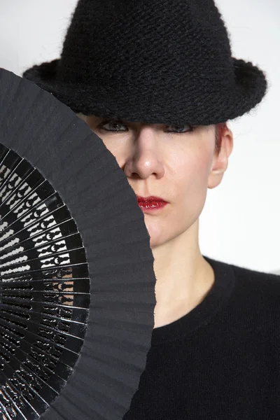 Portrait of woman with black hat and fan