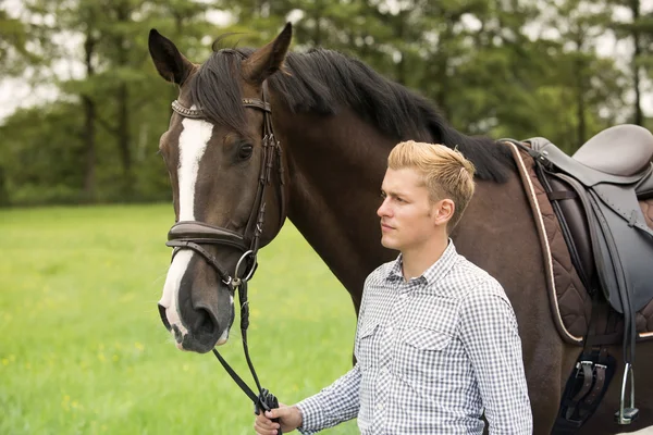 Man walking with his horse on farmland