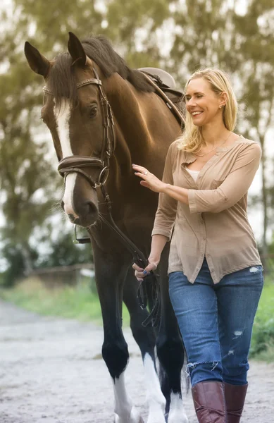 Woman walking with her horse in nature