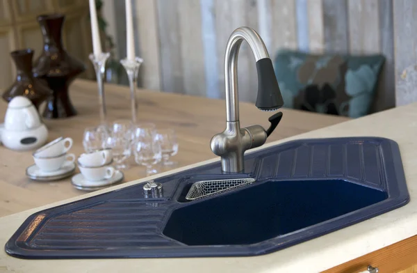 Blue kitchen sink and dining room table with dishes