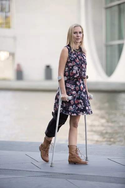 Blonde woman with crutches