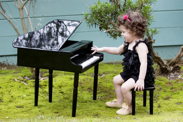Little girl playing on toy piano