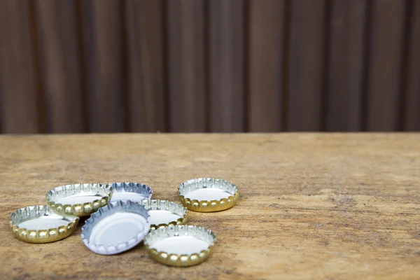 Bottle caps on rustic wooden background