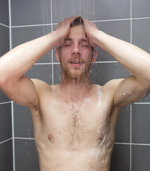 Red-haired man taking a shower