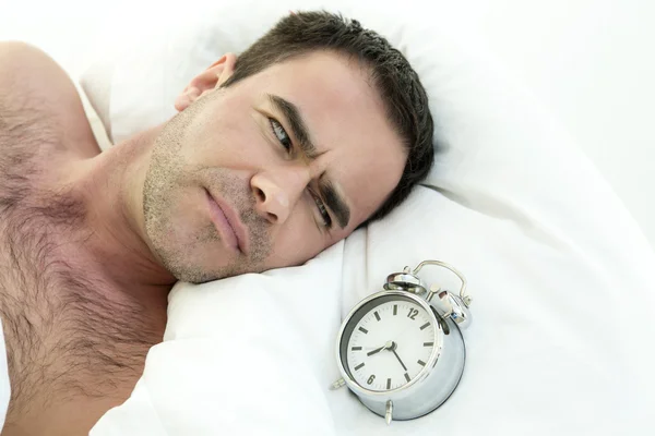 Man in bed with alarm clock