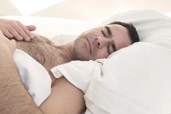 Shirtless man sleeping in bed