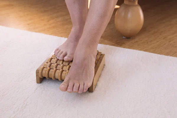 Feet on wooden massage roller