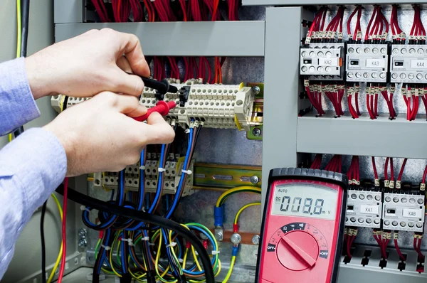 Electrician testing control panel