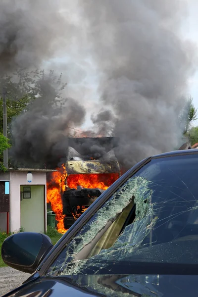Burning truck in an accident with car, broken glass
