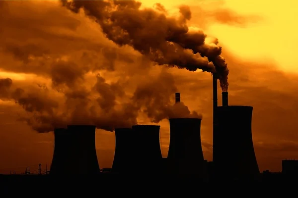 View of smoking coal power plant at sunset