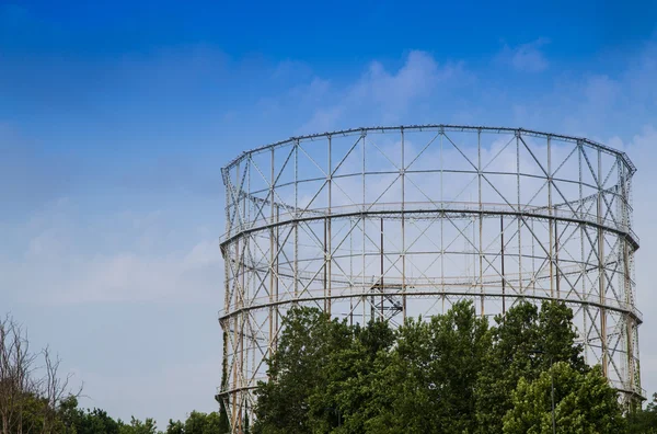 Disused gasometer metal covered with vegetation