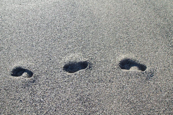 Footprints on the beach of gray stones