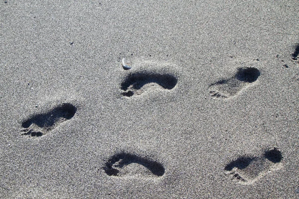 Footprints on the beach of gray stones