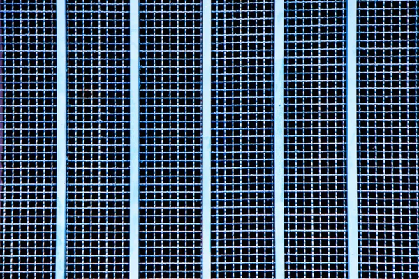 Close up blue metal grille with vertical metal bars