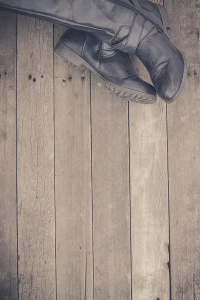 Feet. First-Person view  on rustic wood background.