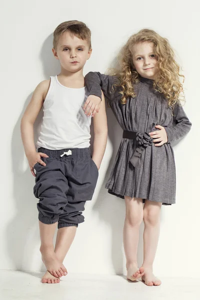 Funny lovely children. Fashionable little boy and girl in grey and white clothes and  barefoot. stylish kids in casual clothes with  different emotions. fashion children