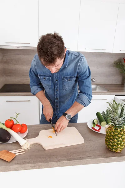 Handsome young man cooking in a modern kitchen.