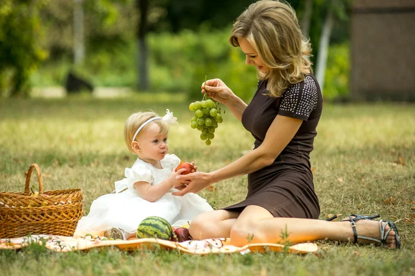 Mother walks with the child in the garden in summer.