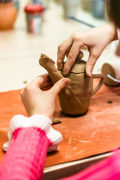 Child sculpts the product from raw clay