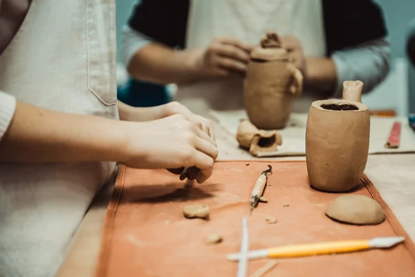 Child sculpts the product from raw clay