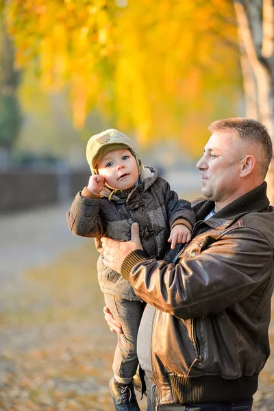 Father playing with his son in the park in autumn.