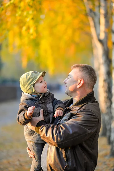 Father playing with his son in the park in autumn.
