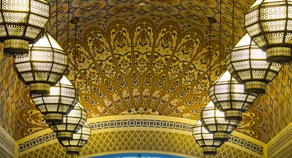 Beautiful mosaic design on ceiling . Ornaments on the walls and chandelier composition