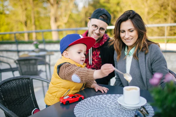 Happy young family in cafe outdoors on sunny day