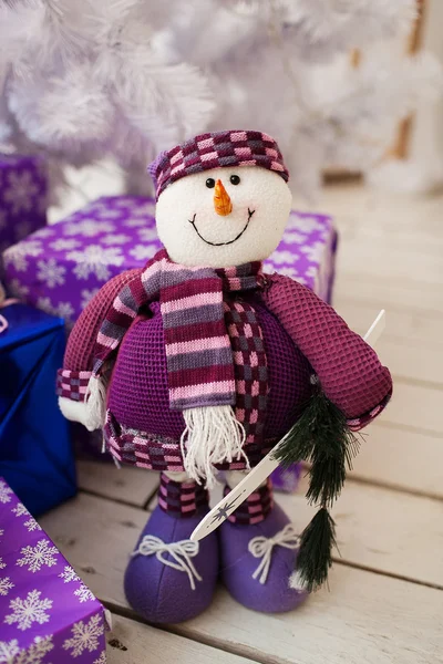 Iceman and white christmas tree with presents indoor