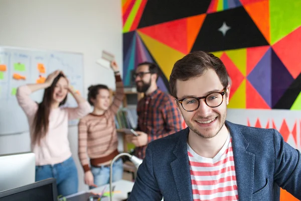 Creative team of four colleagues working in modern office