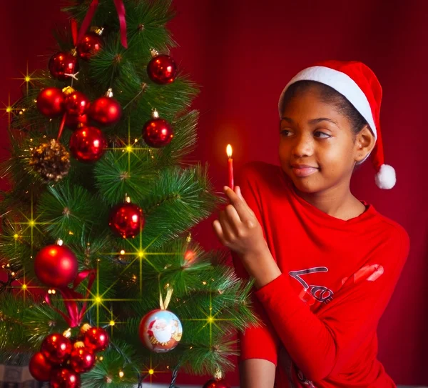 Black little girl decorate the Christmas tree