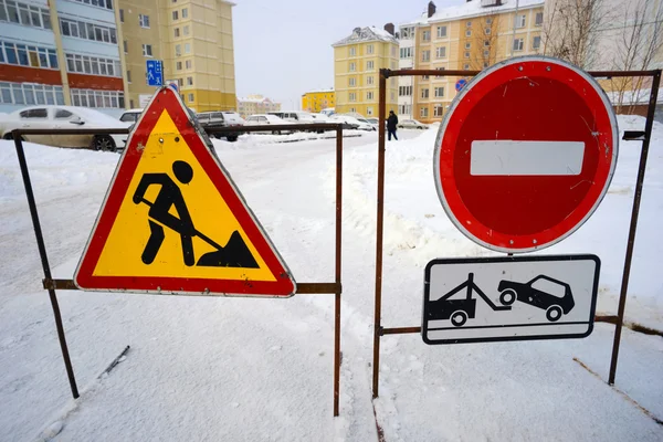 Road signs prohibiting passage when clearing snow in  yards.