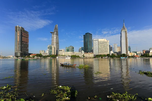 The constrast between rich and poor with skyscrapers on Saigon river at downtown ( center ) of ho chi minh city, Vietnam