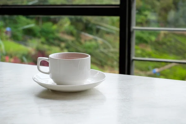 White cup of tea on white marble table in tea shop