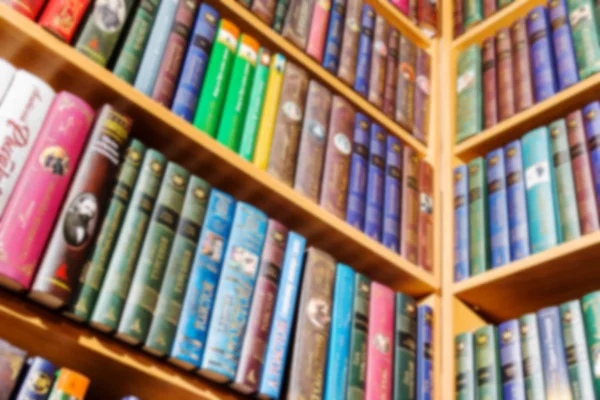 Books standing on the angular bookshelf. blurred image