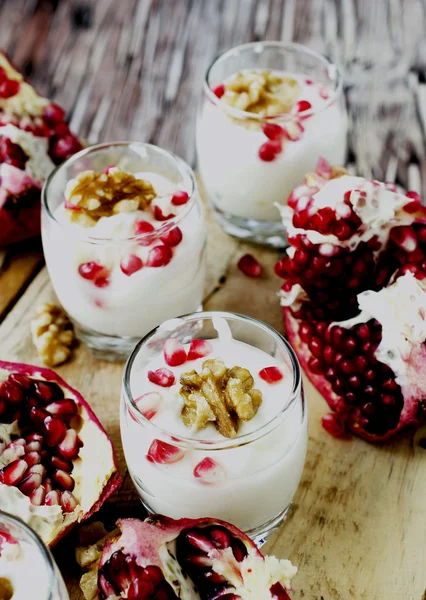 Yogurt dessert with walnuts and pomegranate selective focus