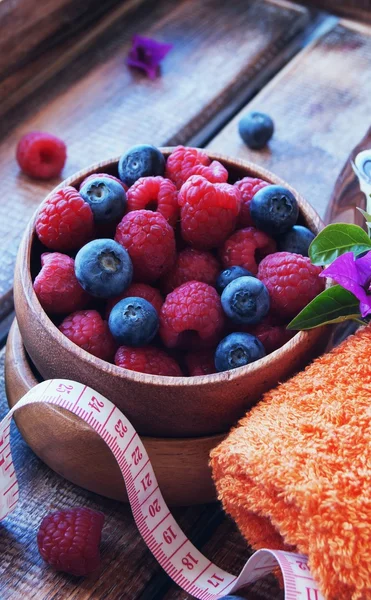 Fitness blueberries and raspberries, towel, centimeter, healthy lifestyle, selective focus