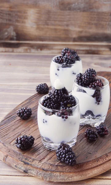 Yogurt cup with blackberry on wooden table