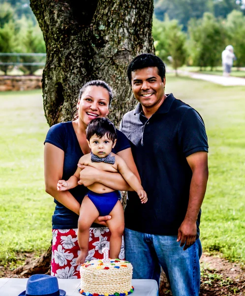 Latino family and baby with birthday cake