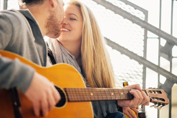 Young beautiful couple  playing guitar and kissing