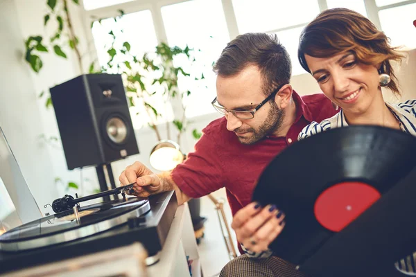 Happy young couple listening to music indoor