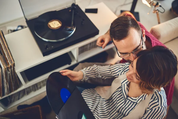 Happy young couple listening to music indoor