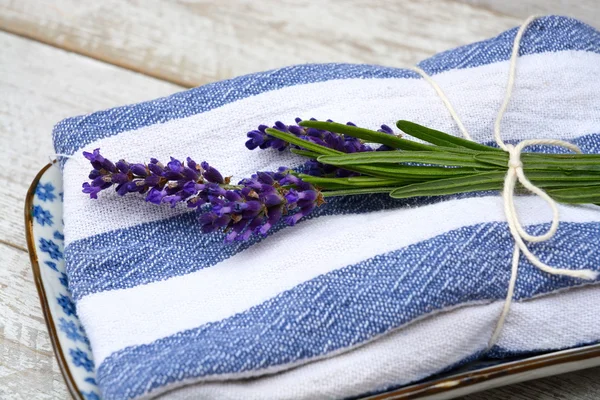 White grey old wooden shelves background with empty copy space and lavender flowers decoration on a blue white towel