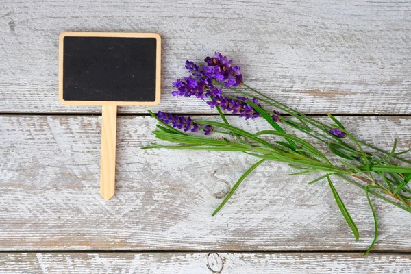 White grey old wooden shelves background with empty chalk board and copy space and lavender flowers decoration