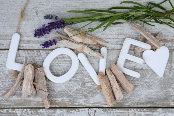 Purple blue Lavender flowers and  wood love letters on a old white wooden shelves background with empty copy space