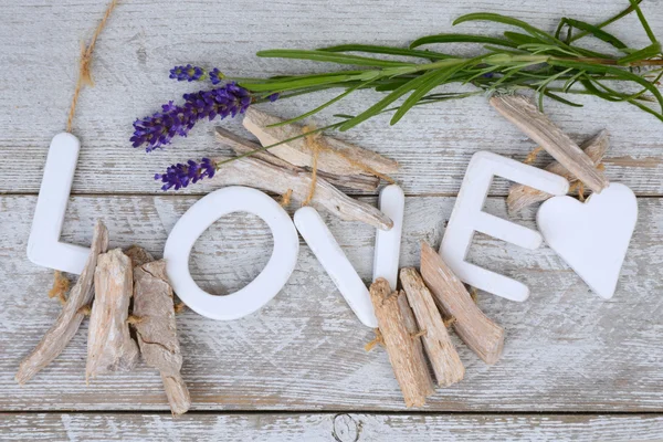Purple blue Lavender flowers and  wood love letters on a old white wooden shelves background with empty copy space