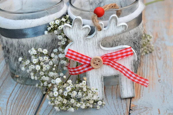 Old wooden grey shelves with red white Christmas decoration such as wooden christmas tree star and heart and candles holder decorated with baby\'s breath flowers