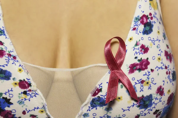 Woman breasts with ribbon for awareness of cancer