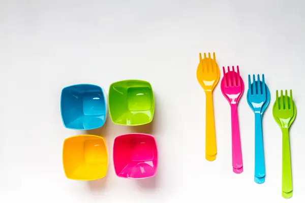 Bright colorful plastic disposable tableware on white background